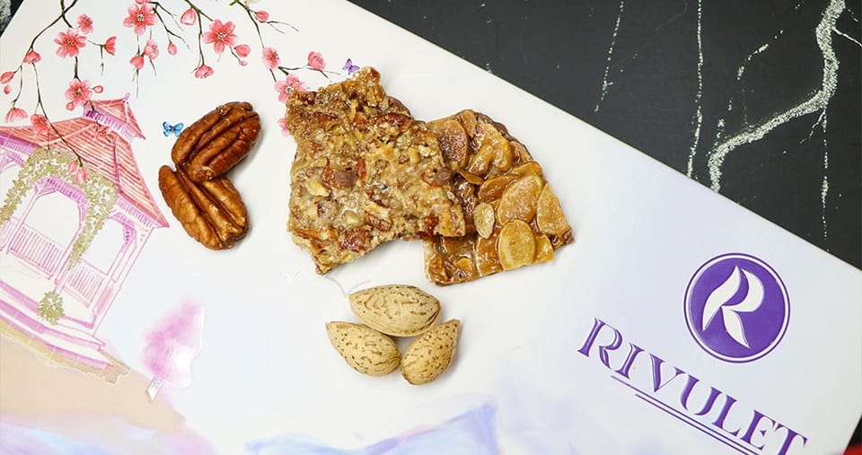 ألواح من الكاكاو البلجيكي الفاخر مغطاة بطبقة مكرملة من قطع جوز البيكان أو شرائح اللوز